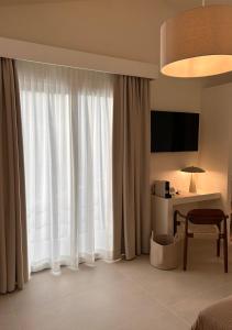 a hotel room with a bed and a desk and a window at Vireo Rooms in Santa Maria Navarrese