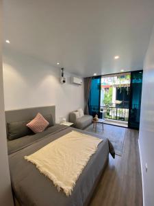 a bedroom with a large bed and a living room at The Eudora Homestay in An Khê