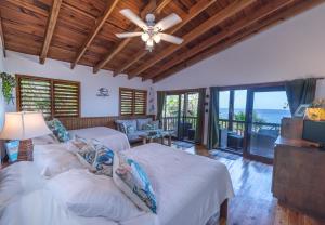 een slaapkamer met twee bedden en een plafondventilator bij Cocolobo Resort in West End