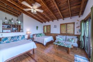 a bedroom with two beds and a couch at Cocolobo Resort in West End +37 photos