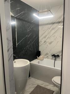 a bathroom with a black and white marble wall at Apartament led w pobliżu Zakopanego ! in Nowy Targ