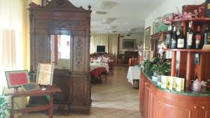 ein Restaurant mit einem Raum mit Tischen und Weinflaschen in der Unterkunft Hotel Due Fontane in Casalpusterlengo