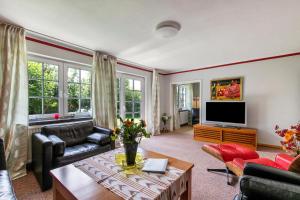 a living room with a couch and a tv at Austernfischer Haus in Pellworm