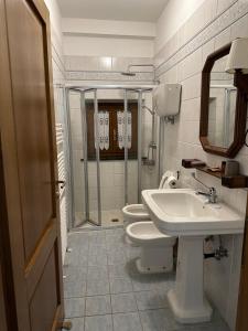 un bagno con due wc, un lavandino e una doccia di The Grapevine by MANVI a Montepulciano