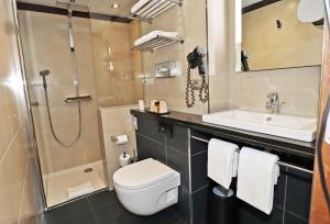 a bathroom with a toilet and a sink and a shower at H&ocirc;tel Hor Europe in Paris