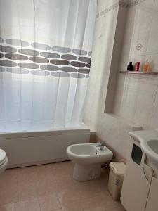 Un baño con inodoro y cortina de ducha. en Appartamento Polisnea, en Polignano a Mare