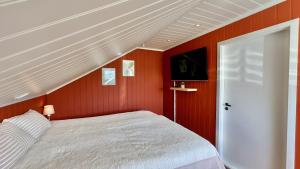 a bedroom with a bed and a red wall at Volandstind Panorama Fredvang Lofoten in Fredvang
