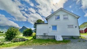 a white house on the side of a road at Volandstind Panorama Fredvang Lofoten in Fredvang