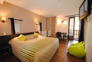 Una habitación de hotel con una cama con almohadas amarillas. en Hostellerie du Perigord Vert-Logis, en Brantôme 50 fotos más