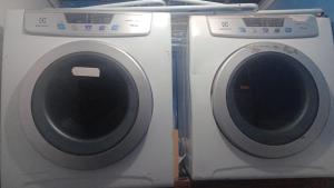 a washing machine and a dryer sitting next to each other at Casarão24horas quartos compartilhados in Cuiabá