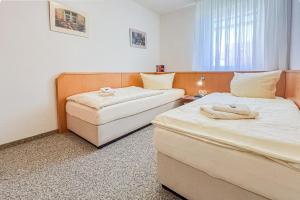 a hotel room with two beds and a chair at Villa Viktoria Whg 16 - "Auskuck" in Kölpinsee