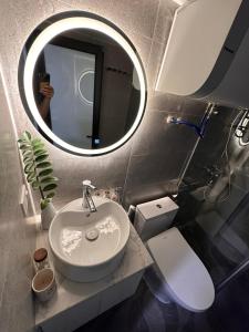 a bathroom with a sink and a mirror and a toilet at The Eudora Homestay in An Khê +193 photos