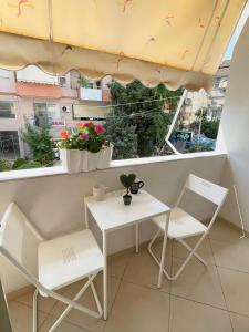 une petite table et des chaises sur un balcon avec une fenêtre dans l'établissement 3S Apartments, à Gjirokastër