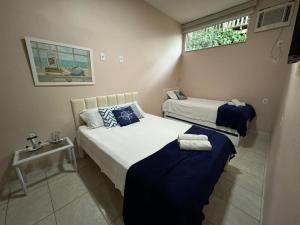 a bedroom with two beds and a window at Pousada Vila Praiana in Arraial do Cabo