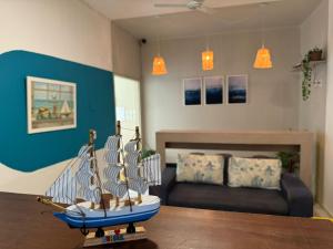 a living room with a model boat on a table at Pousada Vila Praiana in Arraial do Cabo
