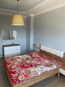 a bedroom with a large bed with flowers on it at penthouse with seaveiw in Vlorë