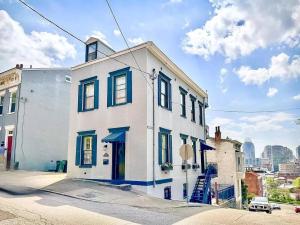 a white building with blue windows on a street at Lux 4BR Townhome - City Views - Free Parking in Cincinnati