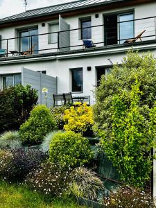 a building with a balcony and a garden at La Villa Perchée, Appartements Élégants, sauna Privé, sport, terrasses et Vue Panoramique, Parking protégé, proche PARIS in Saint-Prix
