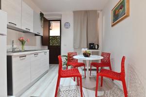 a kitchen with red chairs and a table in a kitchen at IzzHome The Breeze in Cagliari