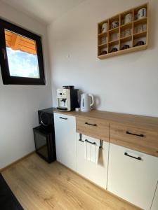 a small kitchen with white cabinets and a window at Mi casa su casa in Lăzarea