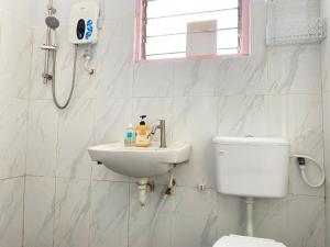 a white bathroom with a toilet and a sink at Home Sweet Home in Kota Kinabalu