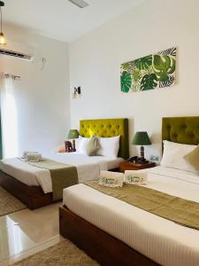 a hotel room with two beds at J Leaf Hotel By Blue Bird in Negombo
