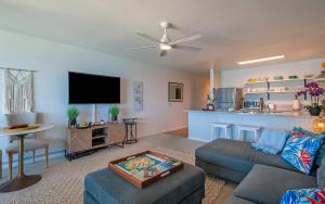 Una sala de estar con un sofá y un televisor de pantalla plana. en Wailua Bay View 302, en Kapaa