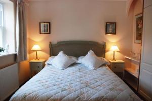 a bedroom with a bed with two lamps on both sides at Rose Cottage, Chipping Campden in Chipping Campden
