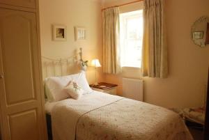 a bedroom with a bed and a window at Rose Cottage, Chipping Campden in Chipping Campden