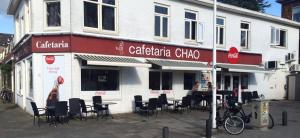 a building with chairs and tables in front of it at Hotel-Chao NL 24 hours open in Utrecht