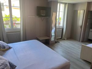 a bedroom with a bed and a tv in it at L'Artimon by les Ambassadeurs - Saint Malo Plage in Saint Malo