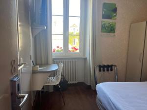 a bedroom with a bed and a desk and a window at L'Artimon by les Ambassadeurs - Saint Malo Plage in Saint Malo