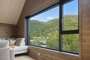a living room with a large window and a couch at Mountain View Apartment - penthouse in Stranda