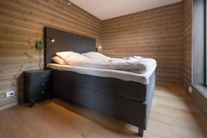 a bed in a room with a wooden wall at Mountain View Apartment - penthouse in Stranda