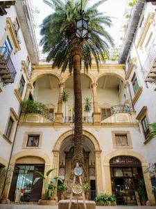una palma davanti a un edificio di Palazzo Santa Ninfa - Luxury Mansion a Palermo