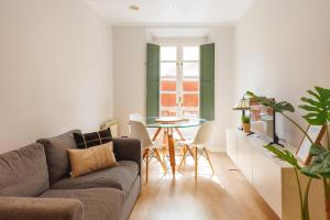 una sala de estar con un sofá y una mesa en Bravissimo Apartaments Mora 4, en Girona