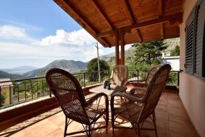 a table and chairs on a balcony with a view at Countryside house in Vlorë