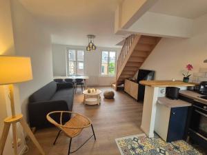 a living room with a couch and a staircase at Maison Les 4 Mers in Eu