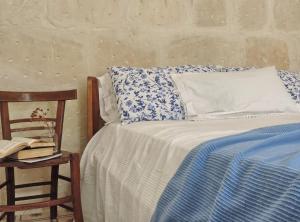 パラッツォーロ・アクレイデにあるIl Vulcanoのベッド1台(青と白の枕、椅子付)