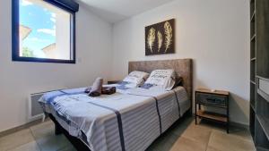 a bedroom with a bed in a room with a window at Maison de ville, Jacuzzi,garage in Bernis