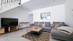 a living room with a couch and a tv at Maison de ville, Jacuzzi,garage in Bernis