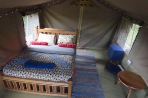 a bedroom with a bed in a tent at Oseki Maasai Mara Camp in Narok