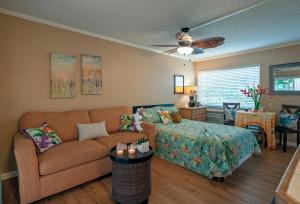 a living room with a couch and a bed at Sandpiper 120B in Princeville
