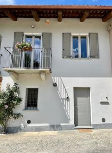 a white building with a balcony and a window at Cascina Luscai - La mansarda in Novello