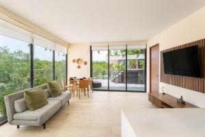 un salon avec un canapé et une télévision dans l'établissement Mistiq Temple I, à Tulum