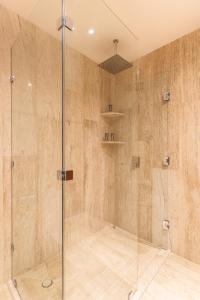 une douche avec une porte vitrée dans une salle de bain dans l'établissement Mistiq Temple I, à Tulum