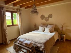 une chambre avec un grand lit avec des serviettes dessus dans l'établissement Chalet dans un écrin de verdure avec SPA privatif, à Jeanménil