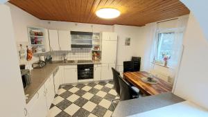 a kitchen with white cabinets and a wooden table at Apartment de luxe 73 qm mit 3 Zimmer und Terrasse in Einhausen
