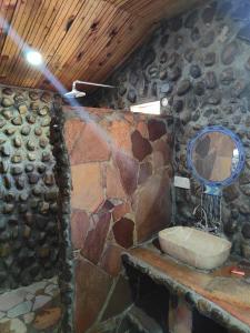 a stone bathroom with a sink and a mirror at Oseki Maasai Mara Camp in Narok