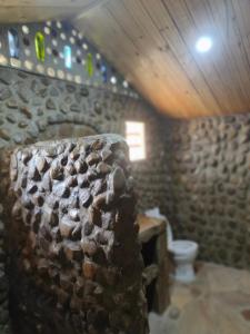 a bathroom with a stone wall and a toilet at Oseki Maasai Mara Camp in Narok
